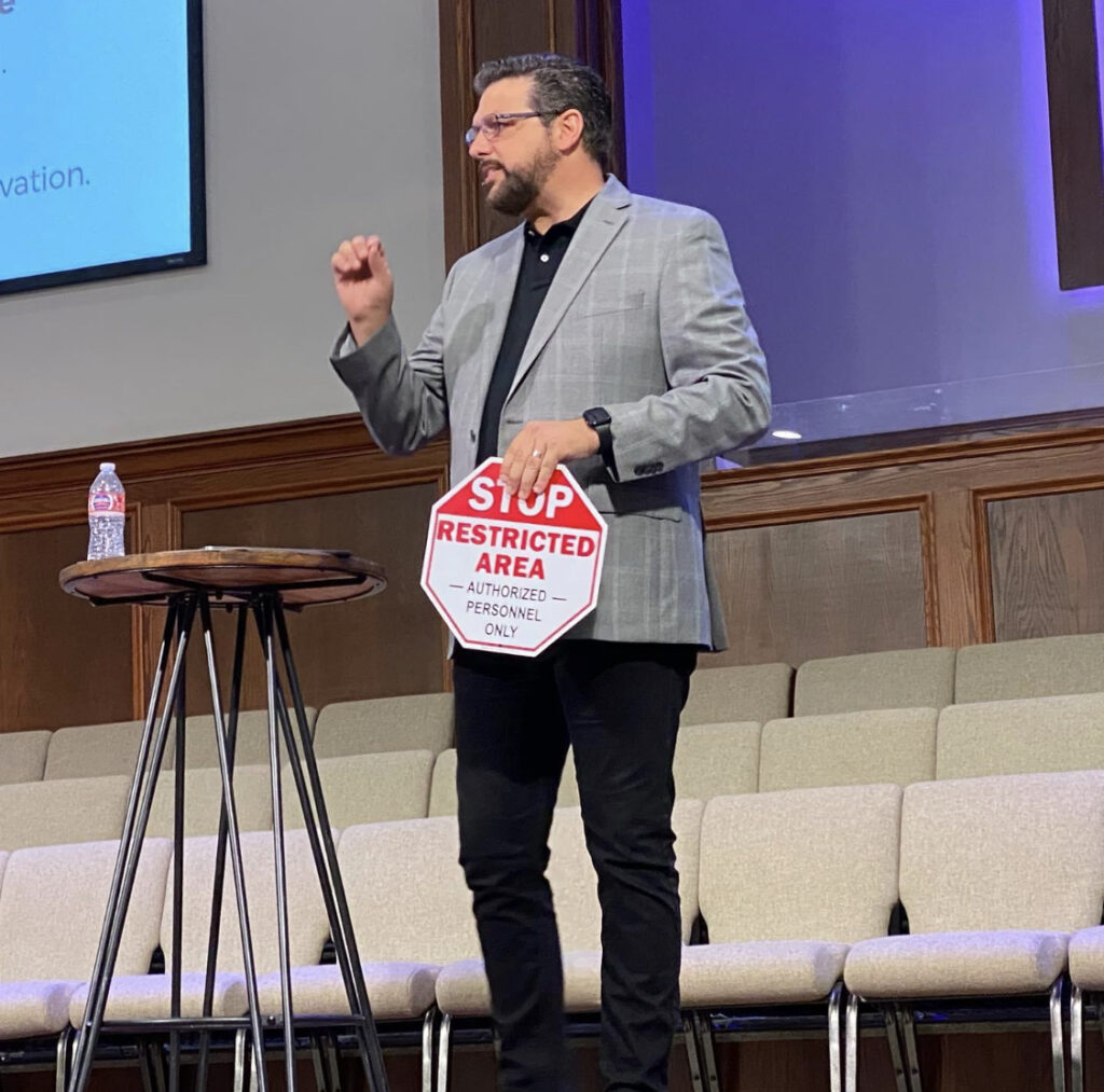 A man standing in front of a podium holding up a sign.